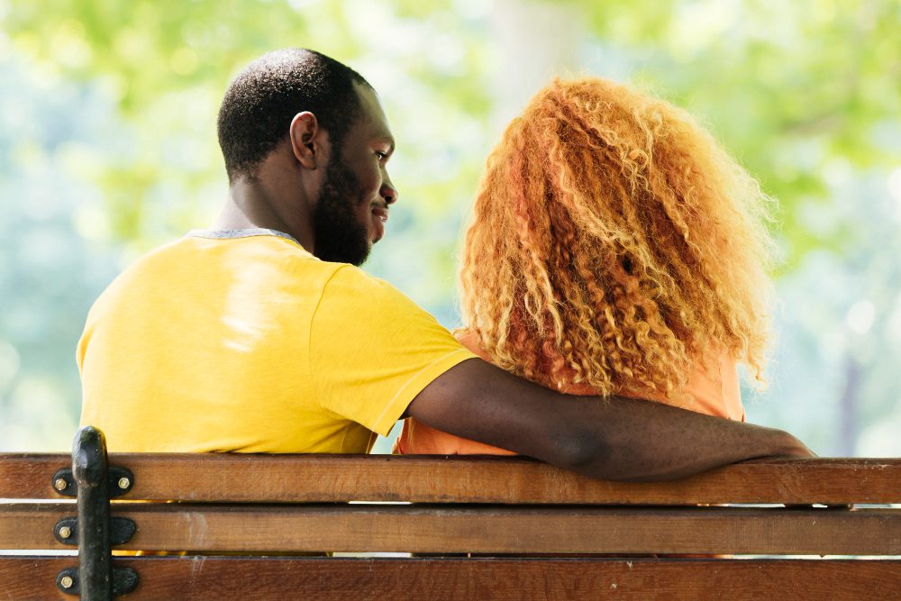 Un couple assis sur un banc et parlant calmement