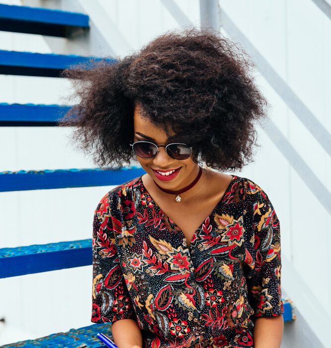femme souriante cherchant quelque chose dans un cahier